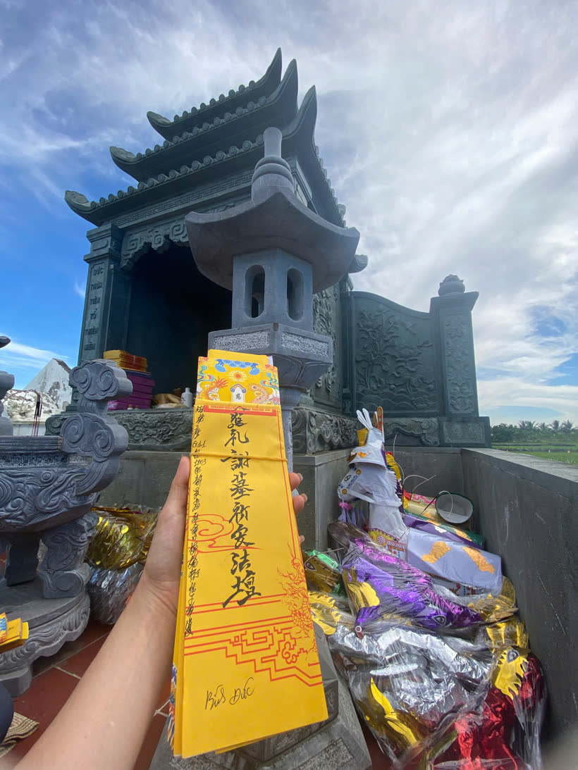 Lá sớ vàng Tạ Mộ Kỳ An Pháp Đàn dâng trong lễ tạ mộ, phía sau là phần mộ đá và lễ vật vàng mã